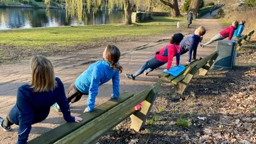 Group exercising outdoors near a lake.