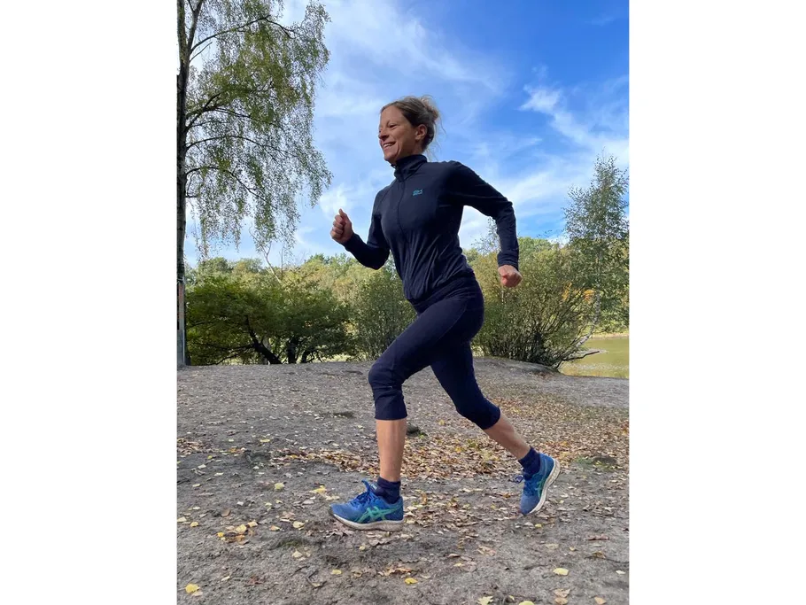 Frau joggt im Freien bei sonnigem Wetter.