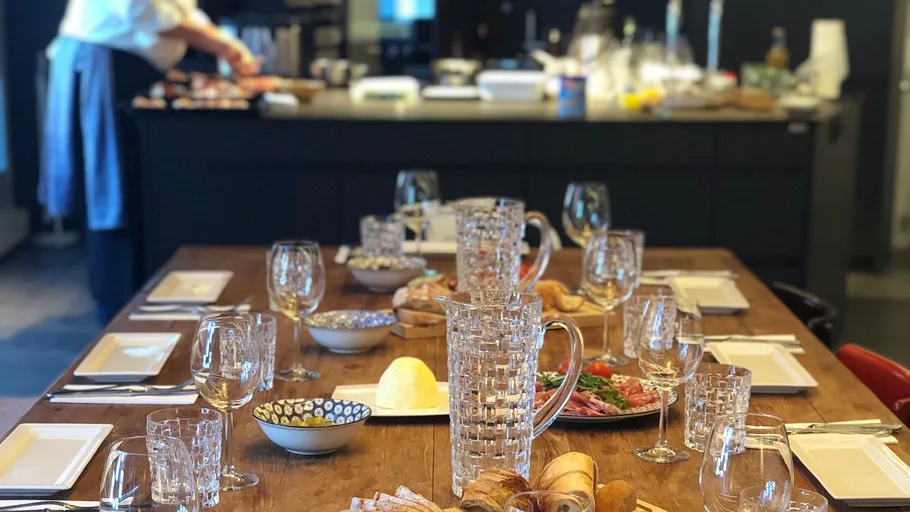 Table set with glassware, cook in background.