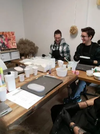 Personen basteln an Holztisch drinnen.