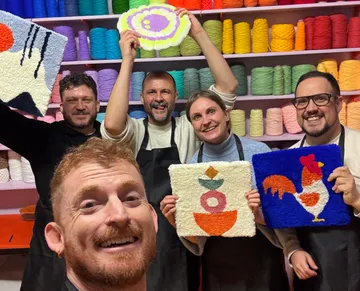 Gruppe hält bunte Textilkunst, Garnhintergrund.