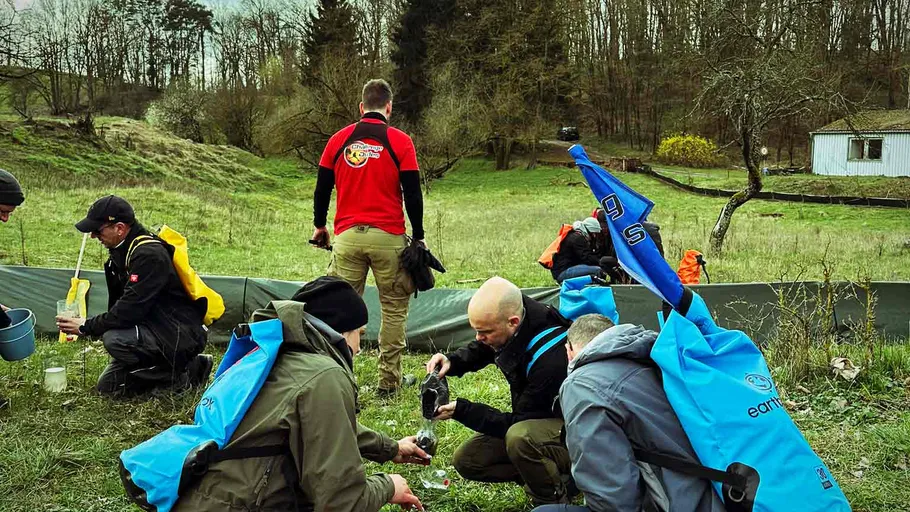Menschen bereiten Ausrüstung auf einer Wiese vor.