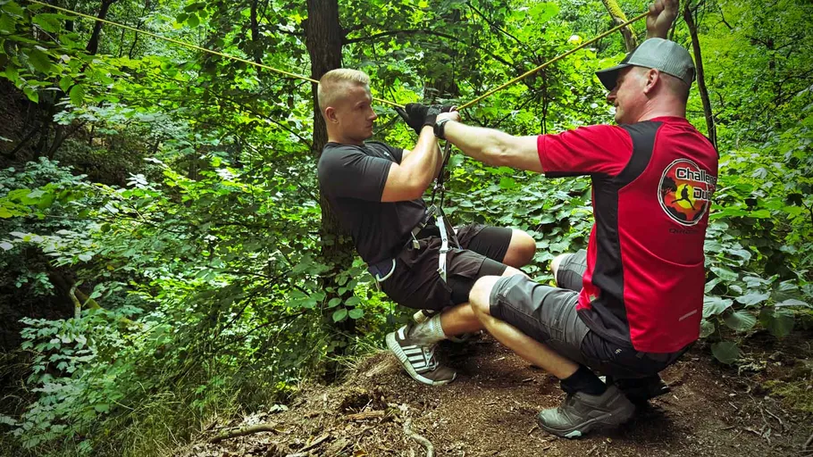 Zwei Männer bereiten sich im Wald auf Seilrutsche vor.