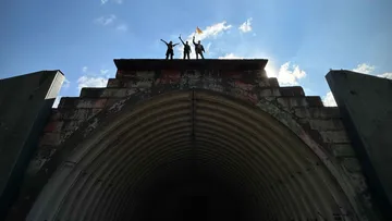 Three people celebrating on tunnel roof.
