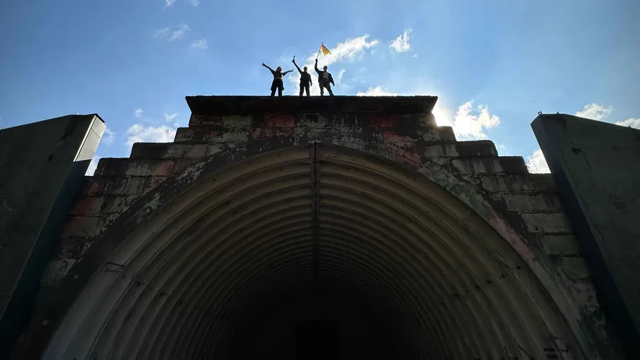 Drei Personen feiern auf Tunnel-Dach.