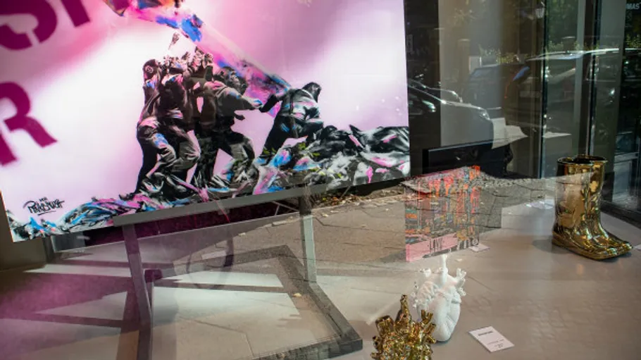 Art display with colorful painting, reflective boots.