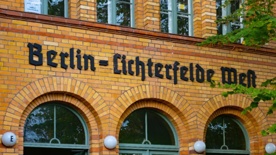 Yellow brick building with station name, trees.