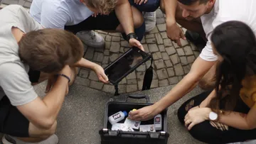 People examining items in an open case.