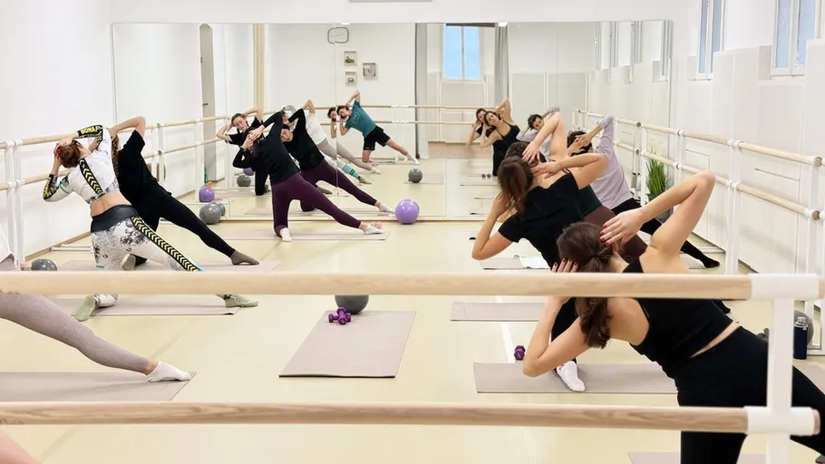 Group exercising in mirrored dance studio.