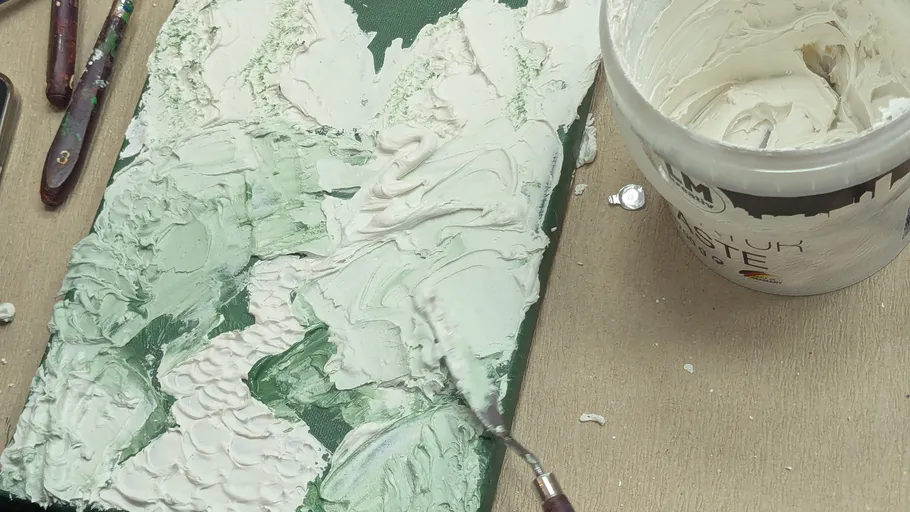 Strukturiertes Gemälde mit Werkzeugen und Paste.