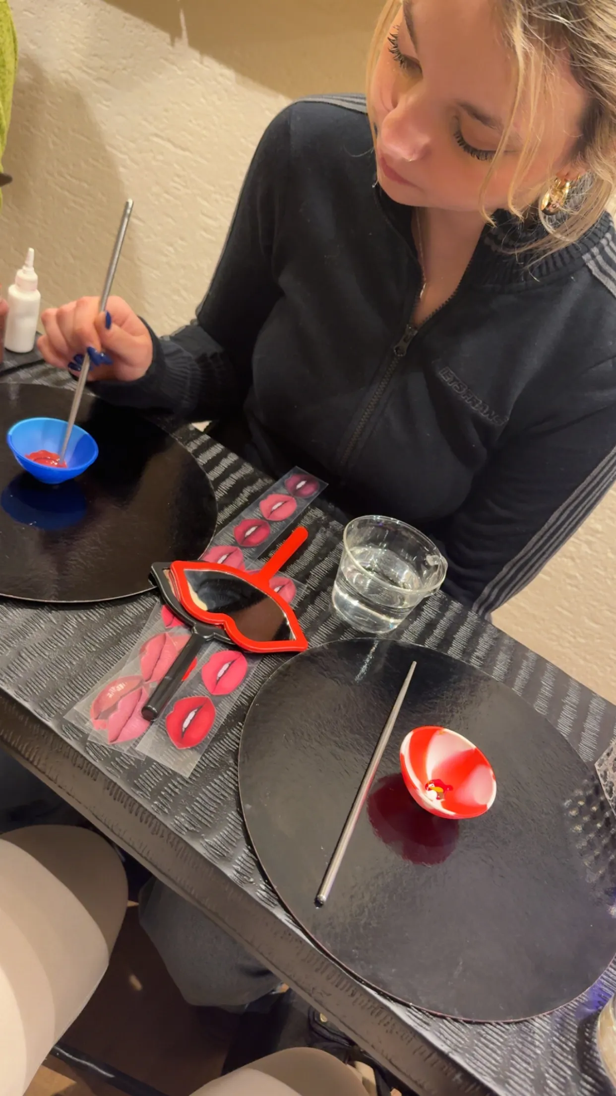 Person sitting with painting tools on table.