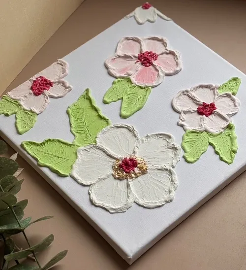 Texturierte Blumen auf Leinwand mit grünen Blättern.