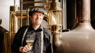 Mann hält Bier in einer Brauerei Umgebung.