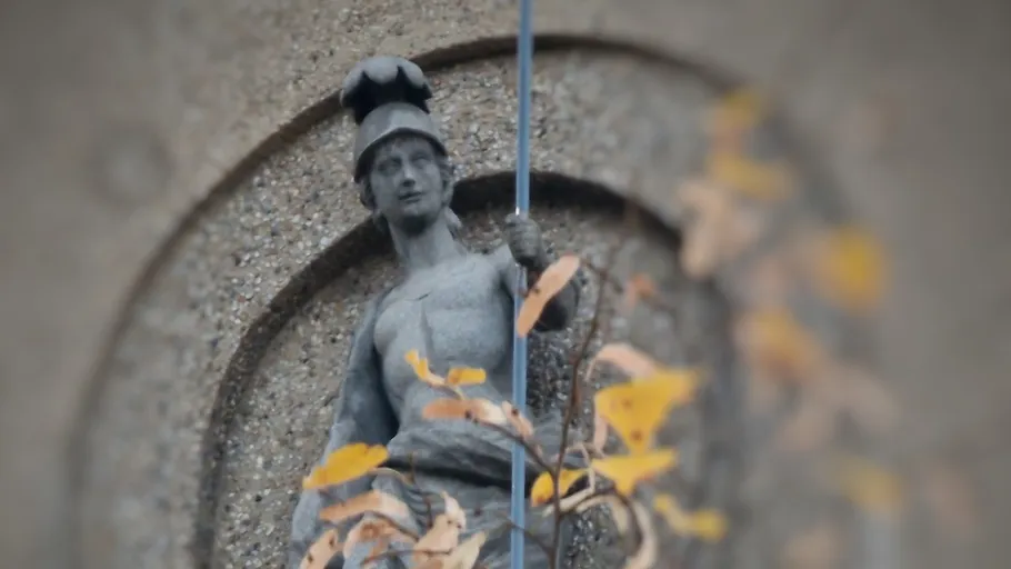 Steinstatue einer gepanzerten Figur mit Speer.