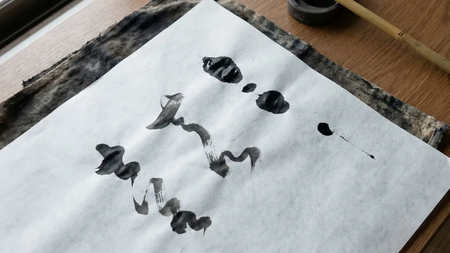 Kalligrafiepapier mit schwarzen Tintenstrichen.