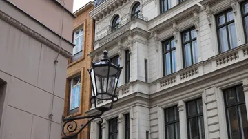 Straßenlampe hängt nahe verzierter Gebäude.