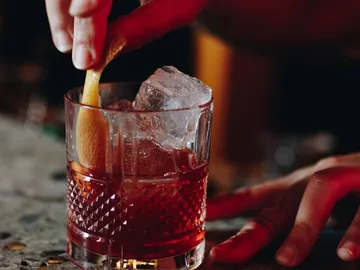 A glass of ice is mixed with a lemon.