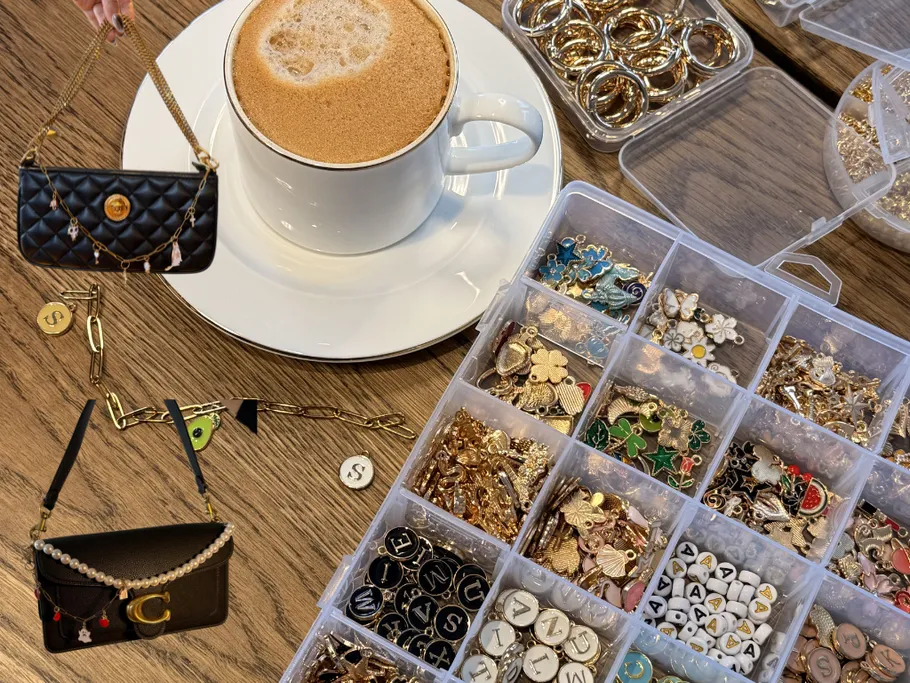 Kaffee, Schmuckanhänger und Handtaschen auf Holztisch.