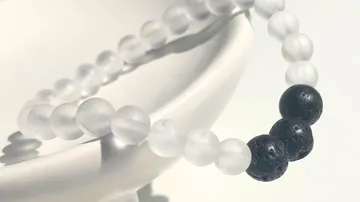 Schwarz-weiße Perlenarmband auf Schale.