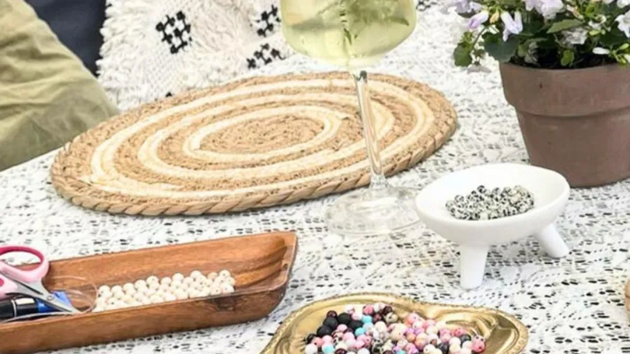 Beads, wine, and flowers on outdoor table.