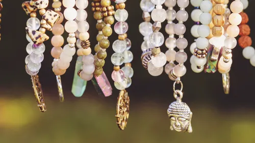 Colorful beaded bracelets hang in sunlight.