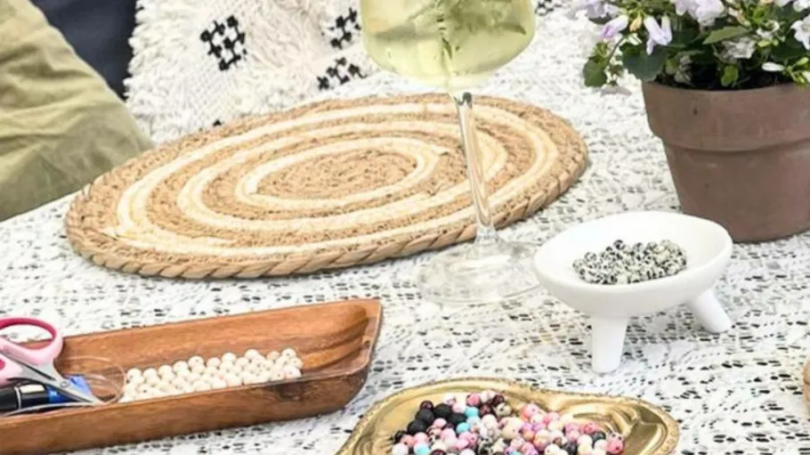 Beads and wine glass on lace tablecloth.