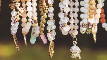 Colorful beaded necklaces hanging outdoors.
