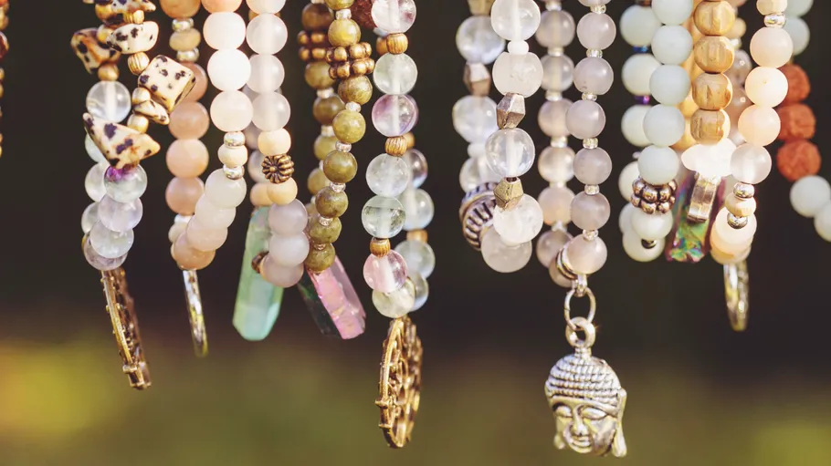 Colorful beaded necklaces hanging outdoors.
