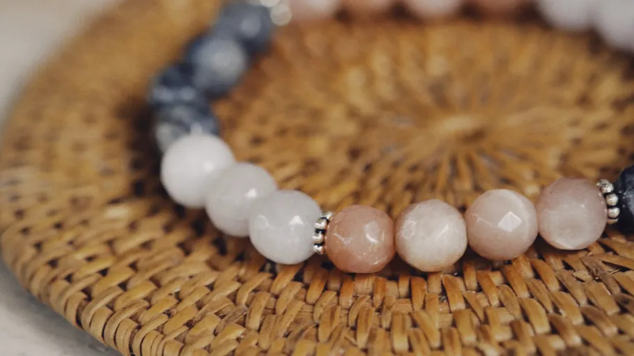 Beaded bracelet on woven surface close-up.