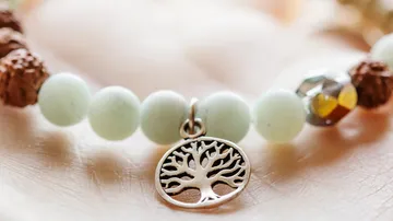 Armband mit Baum-Anhänger auf Hand.