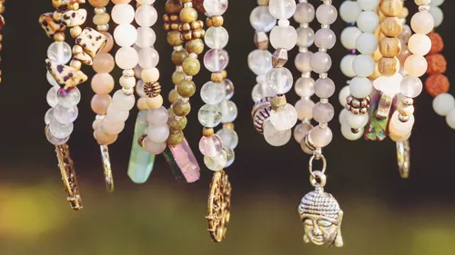 Beaded bracelets hanging against blurred background.