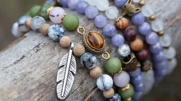 Colorful beaded bracelets with feather charm.