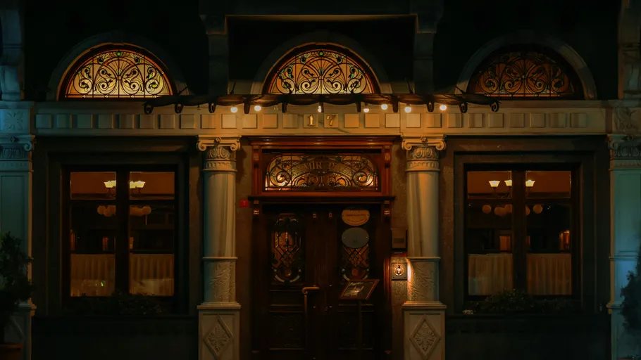 Elegante Restaurantfassade bei Nacht beleuchtet.