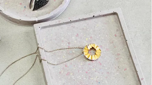 Pencil shaving necklace on terrazzo tray.