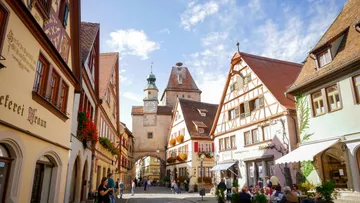 Charmante mittelalterliche Straße mit historischen Gebäuden, Menschen.