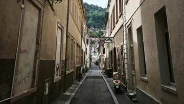 Schmale Gasse mit Rollern und Fahrrädern.