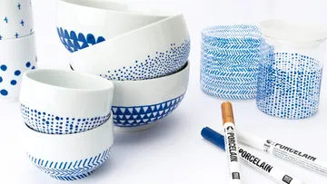 Weiße Schalen mit blauen Mustern auf Tisch.
