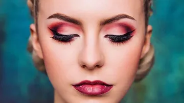 Woman with bold eye makeup, eyes closed.