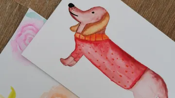 Painted dog in sweater on paper.