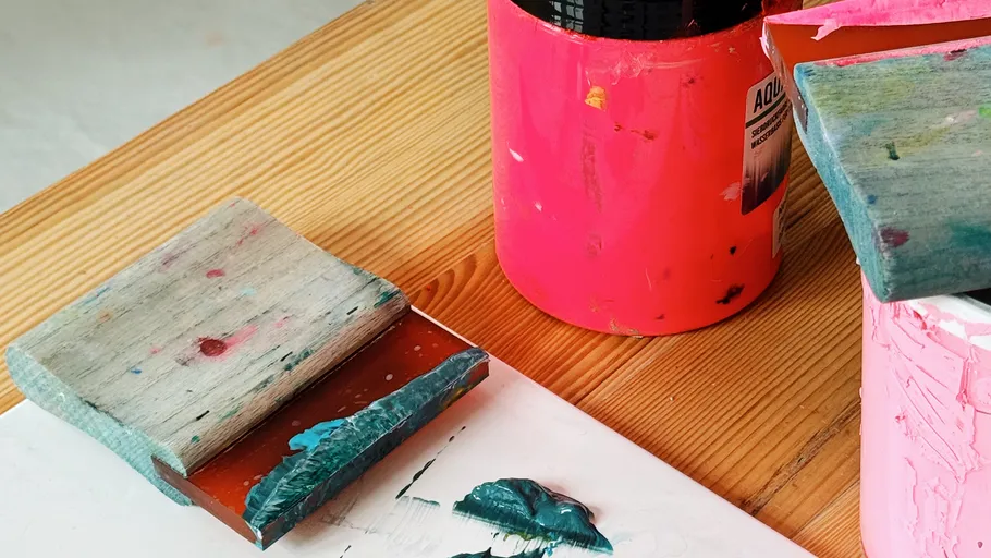 Art tools and paint on wooden table.