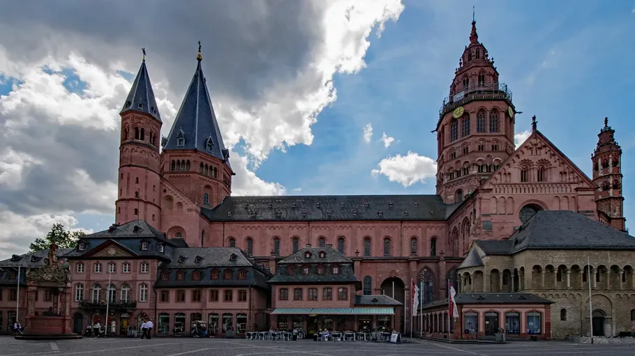 Kathedrale mit Türmen unter bewölktem Himmel.