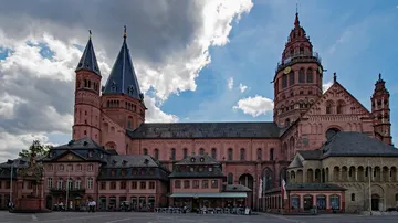 Historical cathedral with towers under cloudy sky.