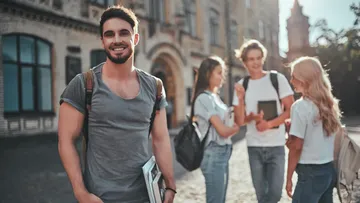 Smiling student with backpack on campus.