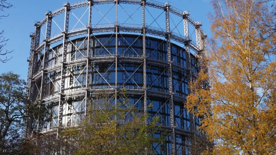 Rundes Gebäude mit Metallrahmen, Herbstbäume.