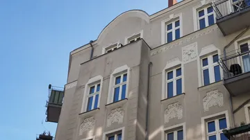 Ornamentierte Gebäudefassade mit Balkonen unter blauem Himmel.