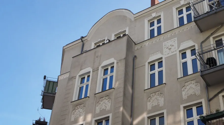 Ornamentierte Gebäudefassade mit Balkonen unter blauem Himmel.
