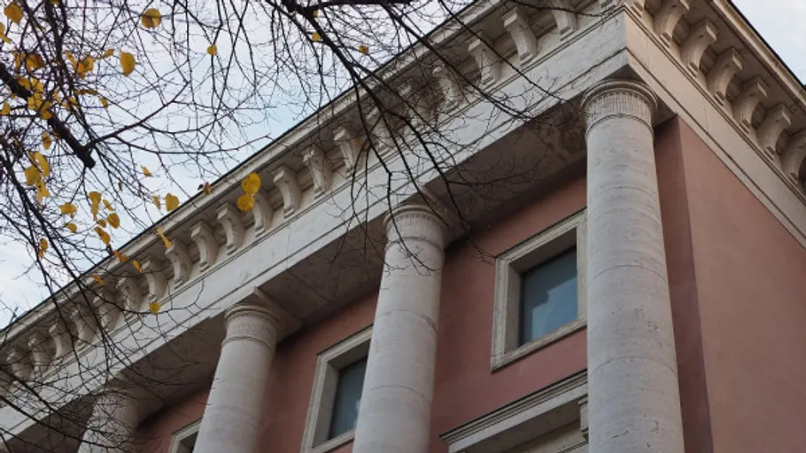 Fassade mit Säulen und kahlen Bäumen