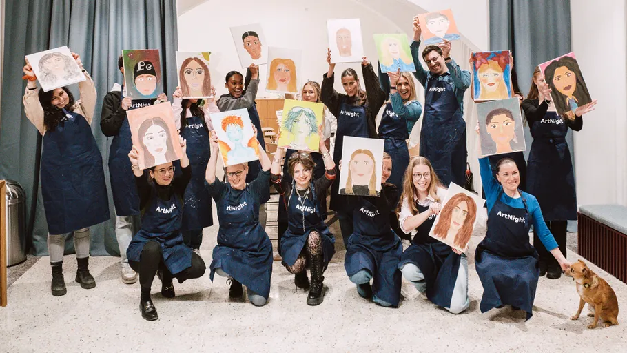 Gruppe zeigt Porträtgemälde im Kunstkurs.
