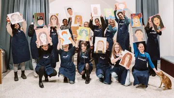 Gruppe hält Porträts im Kunststudio.