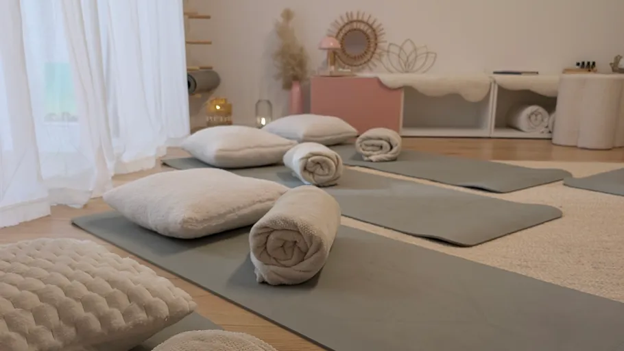 Yogastudio mit Matten, Kissen, ruhiger Atmosphäre.